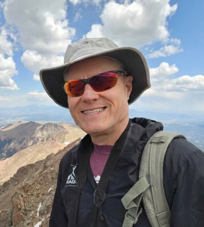 Deric Gunter, founder of Talusmark, on a mountain summit